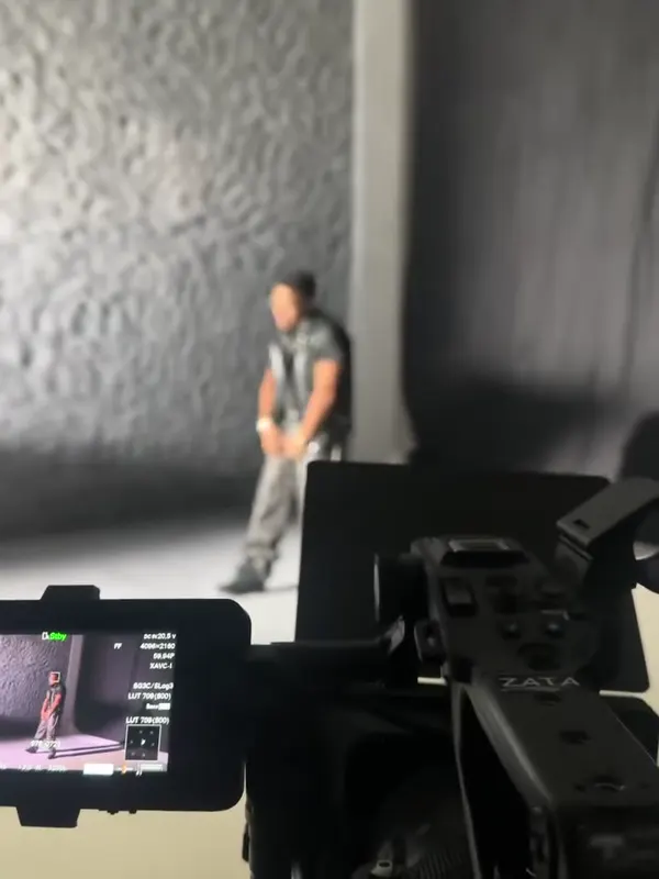 Detrás de cámaras: el monitor de la cámara muestra a Myke Towers posando frente al muro